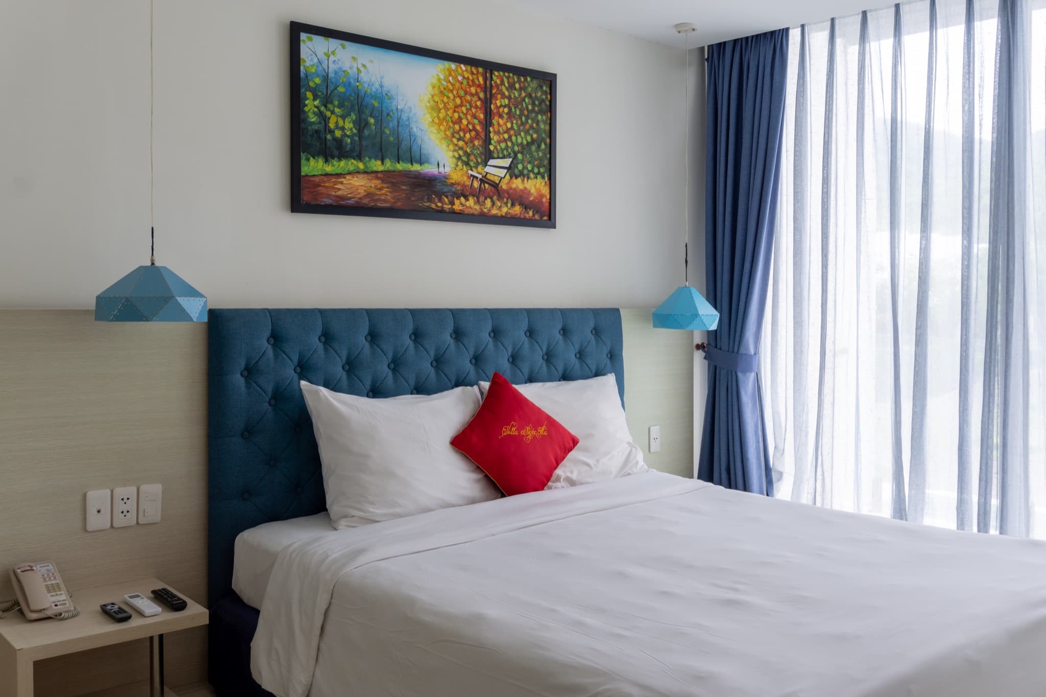 Bedroom one — double bed with blue tufted headboard